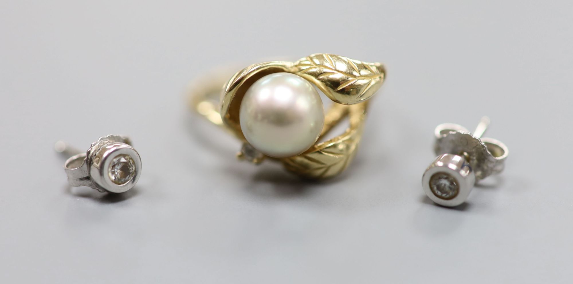 A modern yellow metal (stamped 14k), cultured pearl and diamond chip set dress ring, & pair of earstuds.